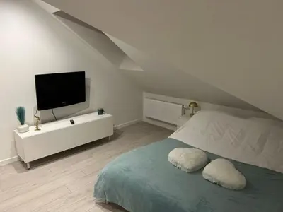a bedroom with a bed with a tv on the wall at Villa Kraków in Kraków