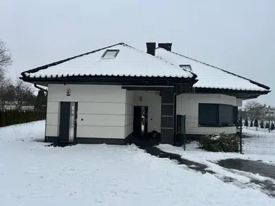 a small white house with snow on the roof at Villa Kraków in Kraków