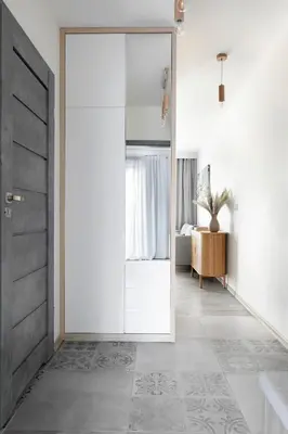 a hallway with a sliding door and a bedroom at Apartament Szary in Kraków