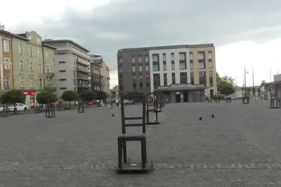 a chair in the middle of a square with buildings at Modern apartament in the Old Town in Kraków