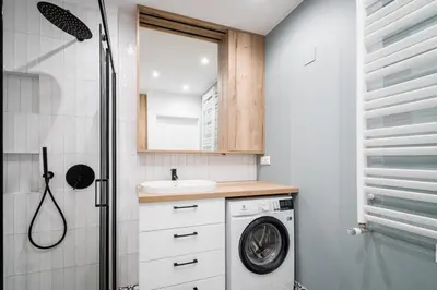 a bathroom with a washing machine and a sink at Dodo Acomodo 7 in Kraków