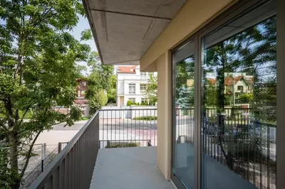 a balcony with glass doors and a view of a street at Dodo Acomodo 7 in Kraków