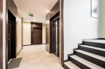 a corridor of a hotel with stairs and doors at Dodo Acomodo 7 in Kraków