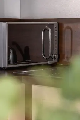 a microwave with a reflection of a person in it at Bright Apartment near ICE Kraków with Air Conditioning and Parking by Noclegi Renters in Kraków