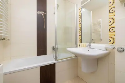 a white bathroom with a sink and a shower at Bright Apartment near ICE Kraków with Air Conditioning and Parking by Noclegi Renters in Kraków