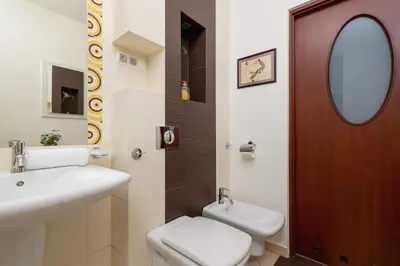 a bathroom with a sink and a toilet and a mirror at Bright Apartment near ICE Kraków with Air Conditioning and Parking by Noclegi Renters in Kraków