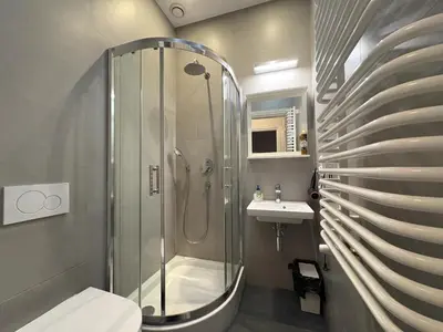 a bathroom with a shower and a toilet and a sink at Central Place Warszawska in Kraków