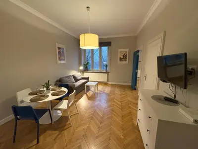 a living room with a table and a couch at Central Place Warszawska in Kraków