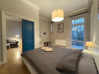 a bedroom with a large bed with a blue door at Central Place Warszawska in Kraków