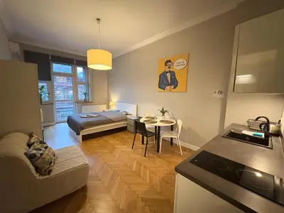 a living room with a bed and a kitchen at Central Place Warszawska in Kraków