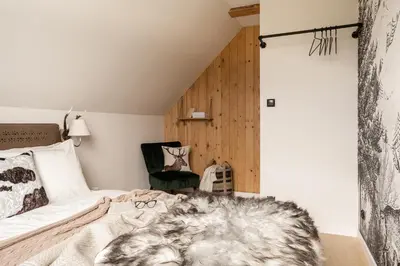 a bedroom with a bed with two shoes on it at Sunset House in Poręba Wielka
