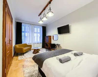 a bedroom with a bed and a chair and a television at Old Town Kraków - Unique Apartment Euphorie in Kraków