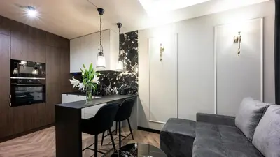 a black and white kitchen with a table and chairs at Native Apartments Kościuszki 39I24 in Kraków