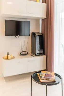 a living room with a table and a tv at Prądnik Czerwony Studio - Balcony, City View - by Rentujemy in Kraków