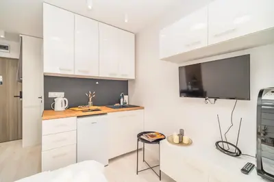 a kitchen with white cabinets and a counter top at Prądnik Czerwony Studio - Balcony, City View - by Rentujemy in Kraków
