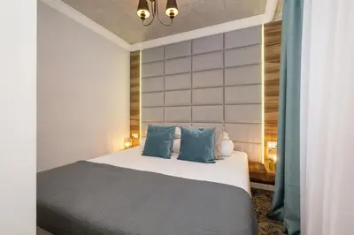 a bedroom with a bed with blue pillows at One bedroom apartment- Rakowicka 6 in Kraków