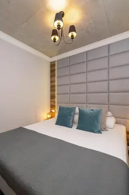 a bedroom with a large bed with blue pillows at One bedroom apartment- Rakowicka 6 in Kraków