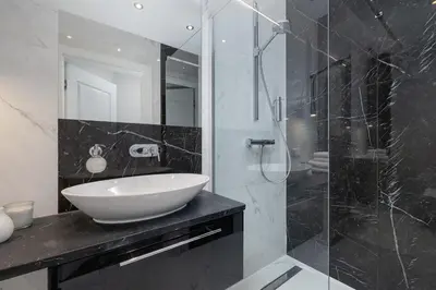 a bathroom with a sink and a glass shower at One bedroom apartment- Rakowicka 6 in Kraków