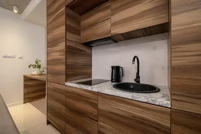 a kitchen with a sink and wooden cabinets at One bedroom apartment- Rakowicka 6 in Kraków