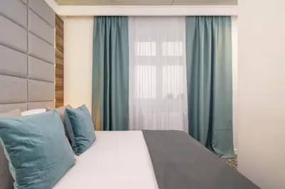 a bedroom with a bed with blue pillows and a window at One bedroom apartment- Rakowicka 6 in Kraków
