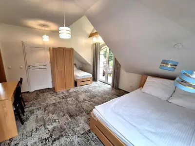 a bedroom with a bed and a desk and a table at Dom z Wanną z Hydromasażem i Sauną - agroturystyka in Mucharz