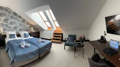 a bedroom with a bed and a desk with a laptop at MedHotel Smart Krupnicza w Krakowie in Kraków