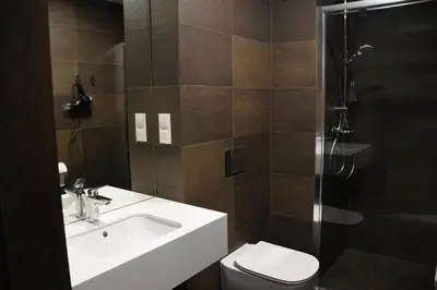 two pictures of a bathroom with a sink and a shower at MedHotel Smart Krupnicza w Krakowie in Kraków
