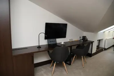 a hotel room with a desk and a bed with a laptop at MedHotel Smart Krupnicza w Krakowie in Kraków