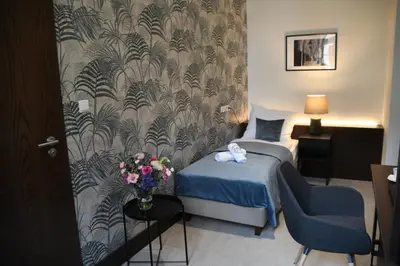 a bedroom with a bed and a desk with a laptop at MedHotel Smart Krupnicza w Krakowie in Kraków
