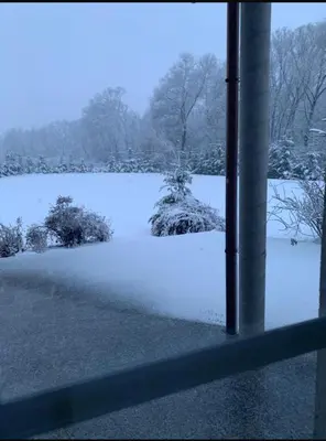 a view of a snow covered field from a window at B-Willa Słopnice basen & jacuzzi, sauna in Słopnice