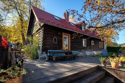 a log cabin with a wooden deck at Pod Wysokim Niebem in Wysokie