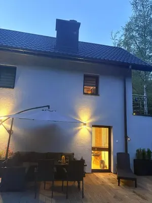 a white house with a couch and a table at Rzeczny Zakątek in Zawoja
