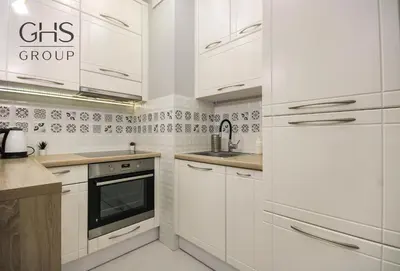 a white kitchen with white cabinets and a sink at Great apartment with a garden in the city center, Old Town in Kraków
