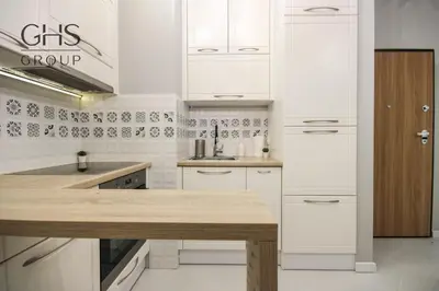 a kitchen with white cabinets and a wooden counter top at Great apartment with a garden in the city center, Old Town in Kraków