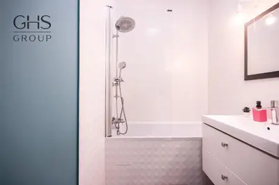 a white bathroom with a shower and a sink at Great apartment with a garden in the city center, Old Town in Kraków