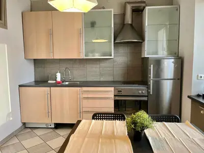a kitchen with wooden cabinets and a stainless steel refrigerator at City Center Apartment in Kraków