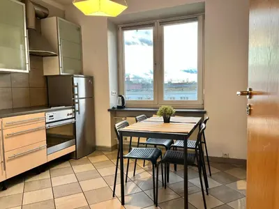 a kitchen with a table and chairs and a refrigerator at City Center Apartment in Kraków