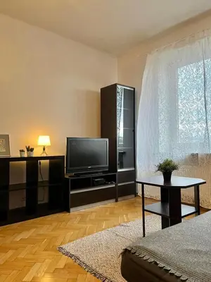 a living room with a television and a table at City Center Apartment in Kraków