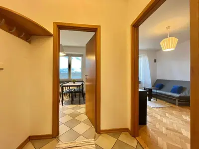 a hallway with a door leading to a living room at City Center Apartment in Kraków