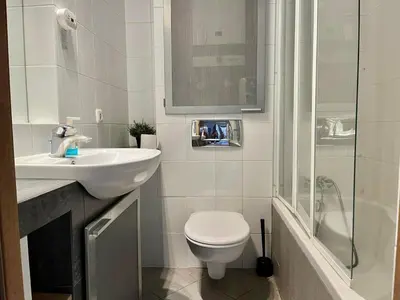 a bathroom with a toilet and a sink and a shower at City Center Apartment in Kraków