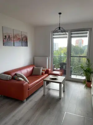 a living room with a red couch and a table at Przestronne mieszkanie Kraków in Kraków