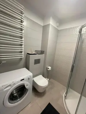 a bathroom with a washing machine and a toilet at Przestronne mieszkanie Kraków in Kraków