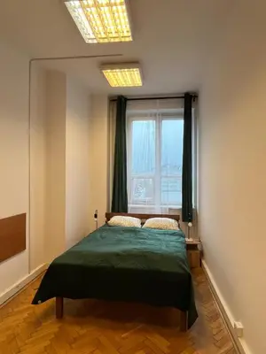 a bedroom with a bed in a room with a window at W94 Hostel in Kraków
