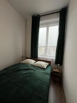 a bedroom with a green bed and a window at W94 Hostel in Kraków