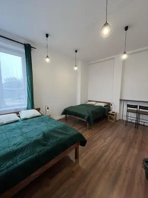 a room with two beds and a piano in it at W94 Hostel in Kraków