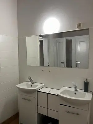 a bathroom with two sinks and a large mirror at W94 Hostel in Kraków