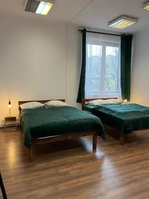 two beds in a room with a window at W94 Hostel in Kraków