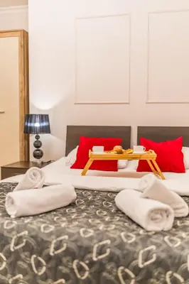 two beds with towels and a tray on top of them at Piasek Apt - Top Location, Patio, Tram&Bus nearby - by Rentujemy in Kraków