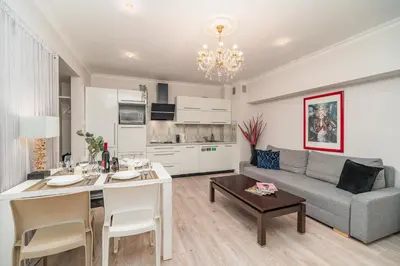 a kitchen and living room with a couch and a table at Piasek Apt - Top Location, Patio, Tram&Bus nearby - by Rentujemy in Kraków
