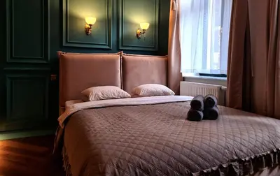 a bed with two pairs of shoes sitting on it at Apartament z Jacuzzi Kraków ART Koletek in Kraków